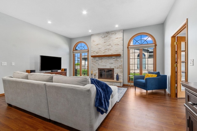 living room featuring a brick fireplace and dark hardwood / wood-style floors