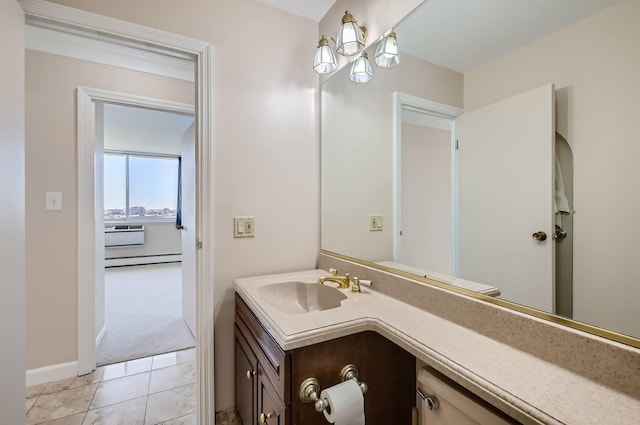 bathroom with tile patterned floors, a baseboard heating unit, baseboards, and vanity