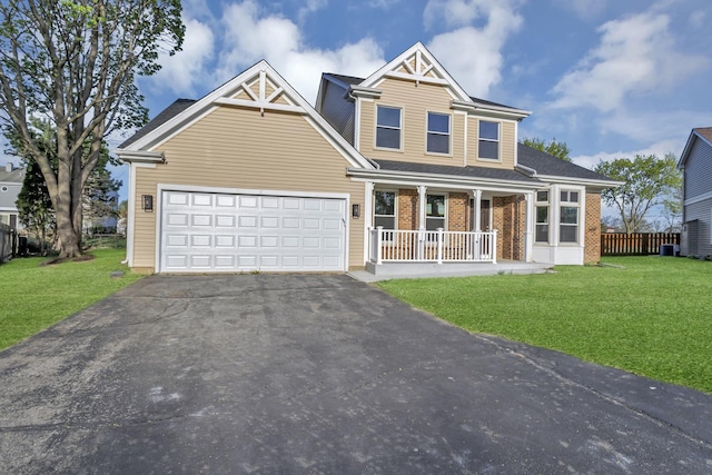 craftsman inspired home featuring a front lawn, an attached garage, brick siding, a porch, and driveway