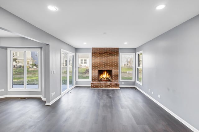 unfurnished living room featuring visible vents, a fireplace, baseboards, dark wood-style floors, and recessed lighting