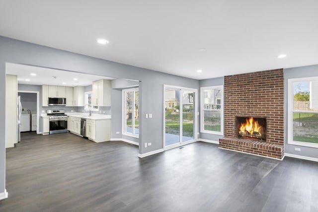unfurnished living room featuring recessed lighting, baseboards, and dark wood finished floors