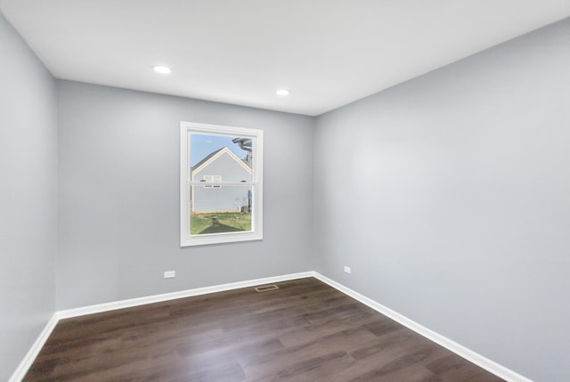 empty room with recessed lighting, baseboards, dark wood finished floors, and visible vents