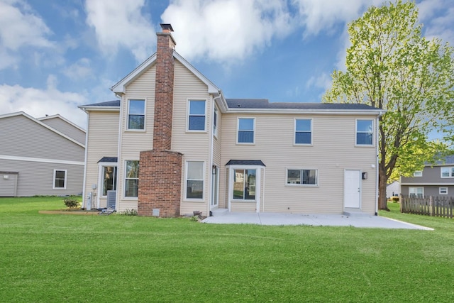 rear view of house featuring a lawn, a patio area, fence, and a chimney