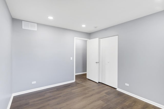 unfurnished bedroom with visible vents, a closet, wood finished floors, baseboards, and recessed lighting