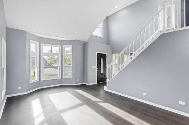 entryway featuring stairs, baseboards, dark wood-style floors, and a high ceiling