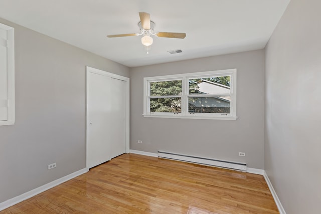 spare room featuring ceiling fan, a baseboard radiator, and light hardwood / wood-style floors