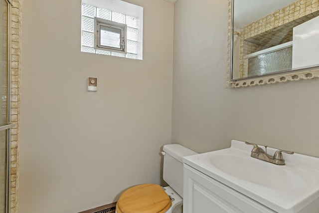 bathroom with vanity, toilet, and an enclosed shower