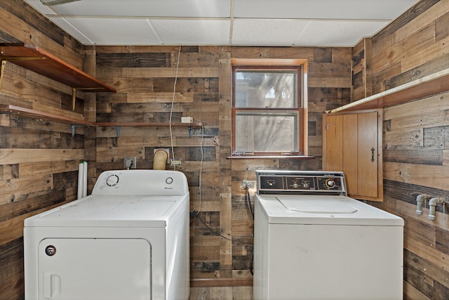 laundry room with washing machine and dryer and wooden walls