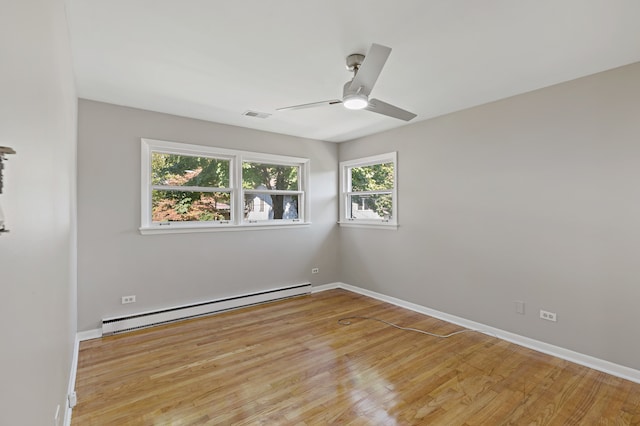 spare room featuring ceiling fan, plenty of natural light, light hardwood / wood-style flooring, and baseboard heating