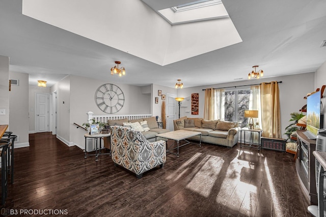 living room with a chandelier, dark hardwood / wood-style floors, and a skylight