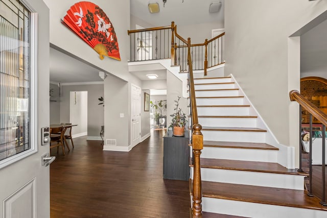 foyer featuring a high ceiling, crown molding, and dark hardwood / wood-style floors