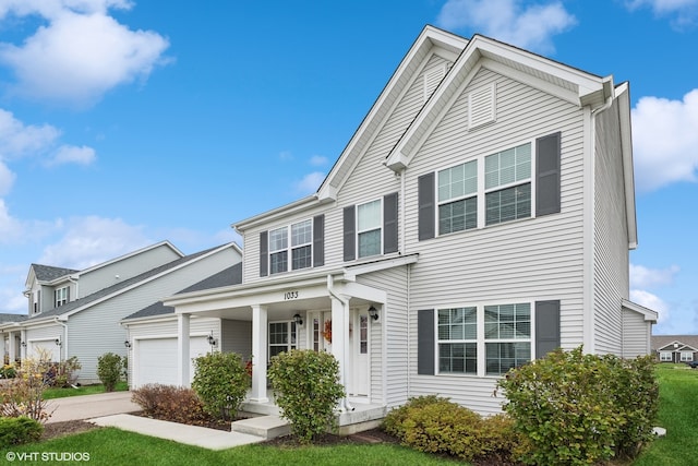 view of front of home with a garage, a porch, and a front lawn