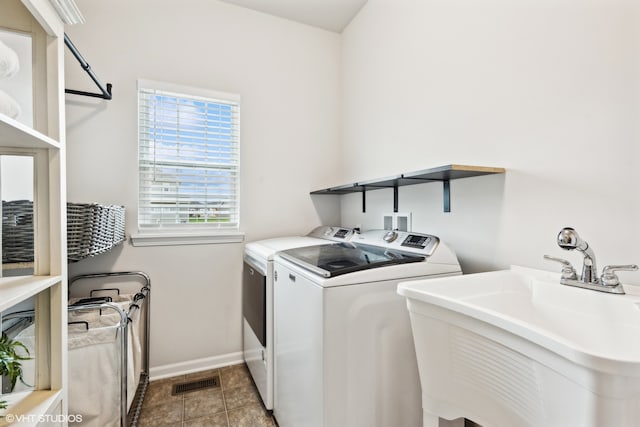 laundry area with washer and clothes dryer, sink, and light tile patterned floors