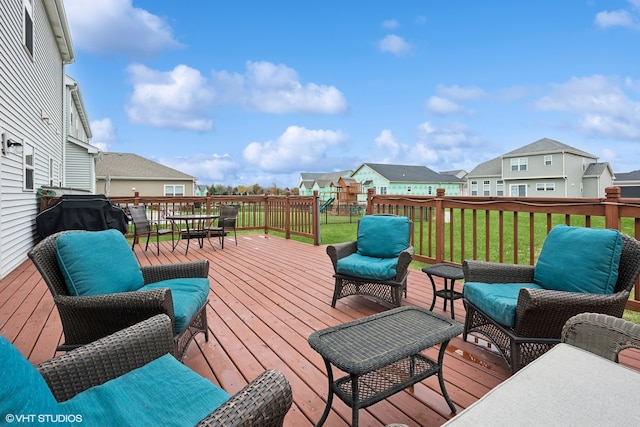 wooden deck featuring a grill, a lawn, and an outdoor living space