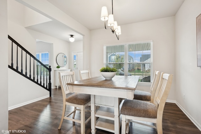 dining room featuring a healthy amount of sunlight, an inviting chandelier, and dark hardwood / wood-style flooring