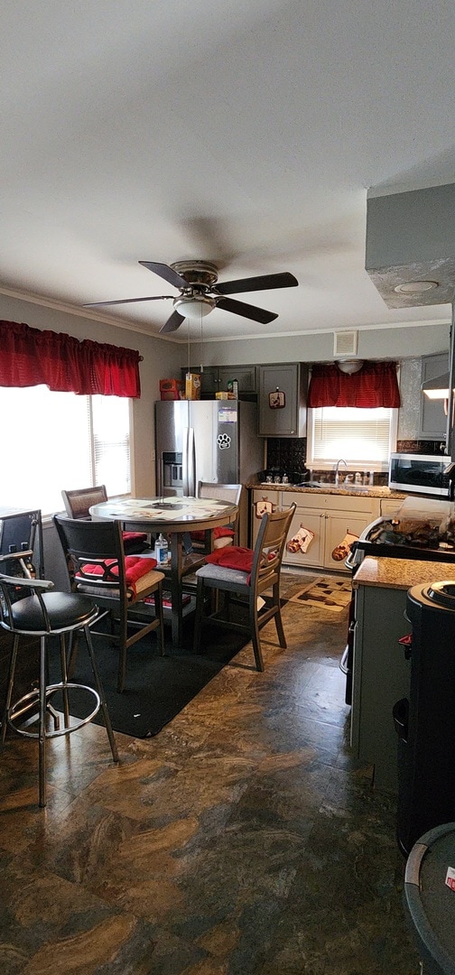 dining room featuring ceiling fan and sink