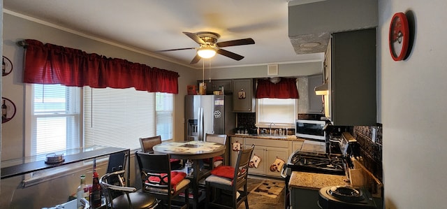 kitchen with ceiling fan, stainless steel appliances, sink, ornamental molding, and backsplash