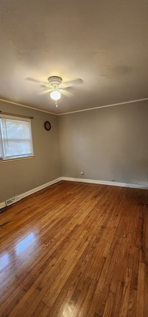 unfurnished room with ornamental molding, hardwood / wood-style floors, and ceiling fan