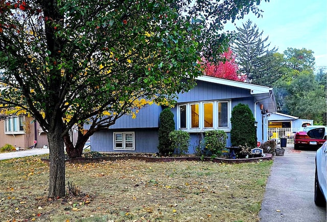 view of home's exterior with a carport and a lawn