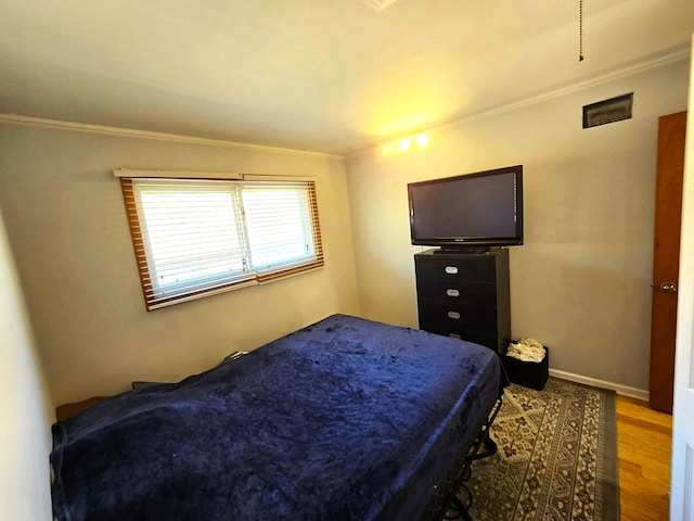 bedroom featuring crown molding and wood-type flooring