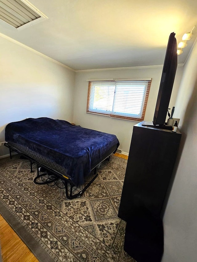 bedroom featuring wood-type flooring and ornamental molding