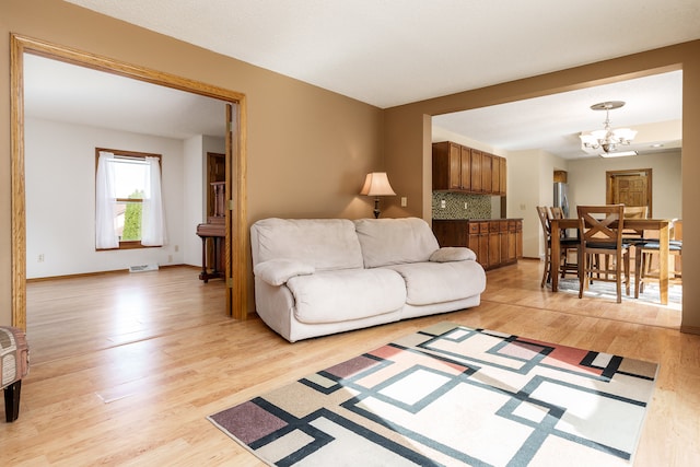 living room featuring a notable chandelier and light wood-type flooring