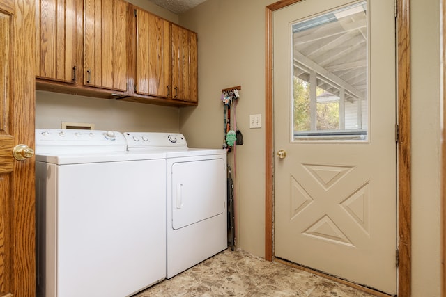 laundry room featuring separate washer and dryer and cabinets