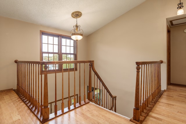 stairs with wood-type flooring and a textured ceiling