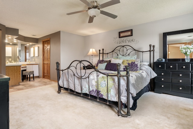 bedroom featuring carpet floors, connected bathroom, a textured ceiling, and ceiling fan