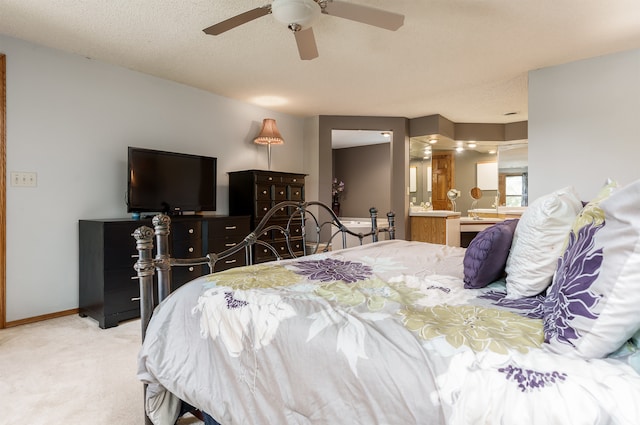 bedroom with light carpet, connected bathroom, a textured ceiling, and ceiling fan