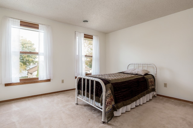 bedroom featuring carpet flooring and a textured ceiling