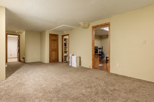 carpeted empty room with a textured ceiling