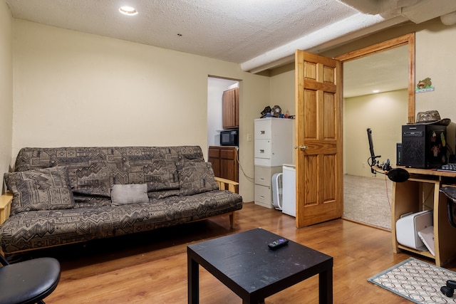 living room with light wood-type flooring and a textured ceiling