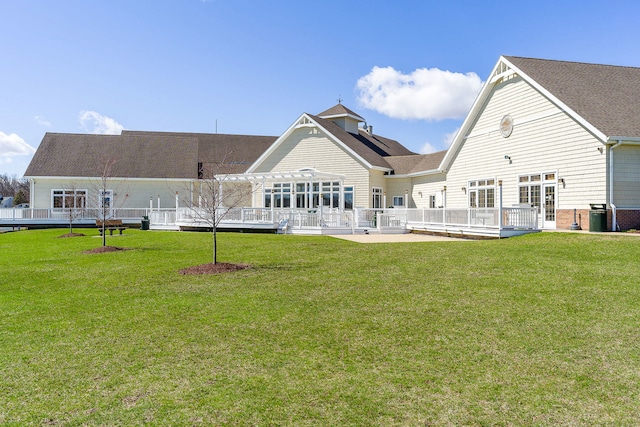 back of house featuring a deck and a lawn