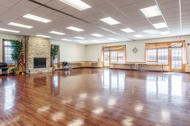 living room with a fireplace, a paneled ceiling, and wood-type flooring