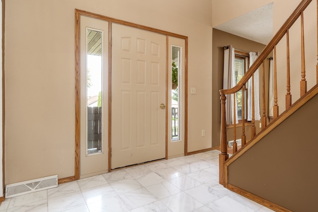 foyer entrance with a textured ceiling and a healthy amount of sunlight