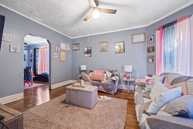 living room featuring crown molding, ceiling fan, dark hardwood / wood-style floors, and a textured ceiling