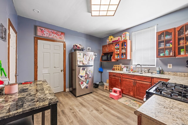 kitchen with stainless steel refrigerator, light hardwood / wood-style flooring, sink, and range