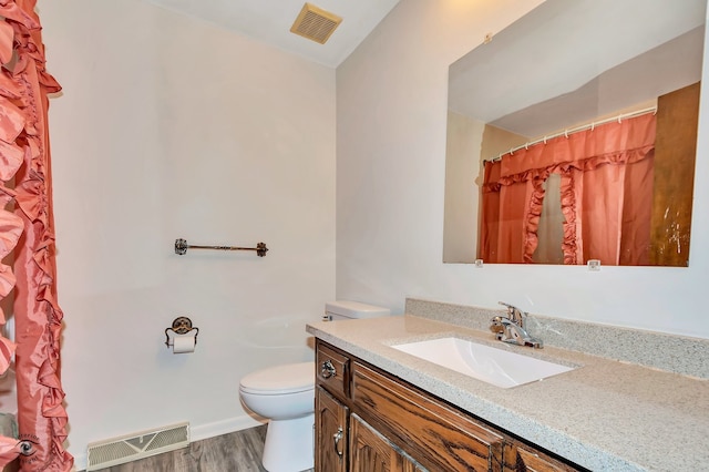 bathroom featuring hardwood / wood-style floors, a shower with shower curtain, vanity, and toilet