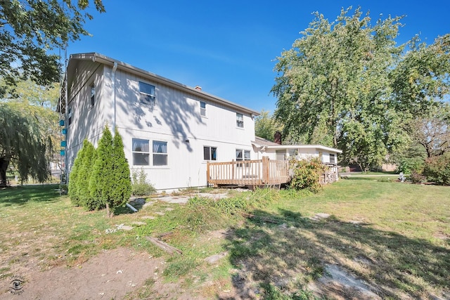 rear view of house featuring a yard and a wooden deck