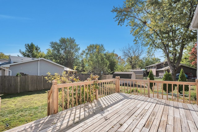 wooden terrace featuring a storage unit and a lawn