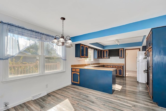 kitchen with light wood-type flooring, wood counters, plenty of natural light, and sink