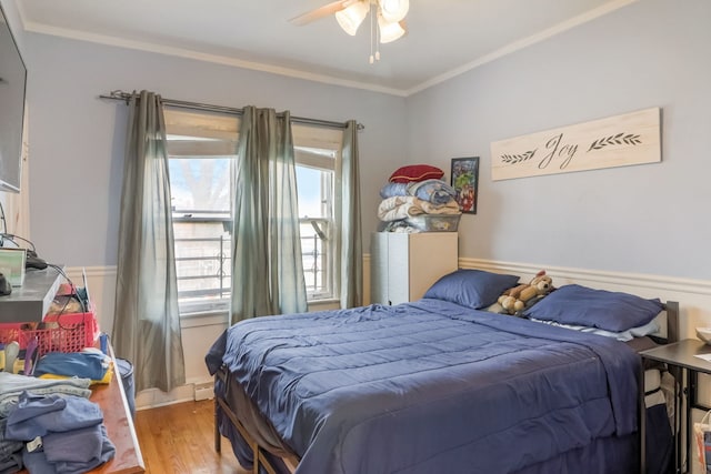 bedroom featuring crown molding, wood-type flooring, and ceiling fan