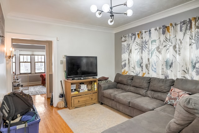 living room with ornamental molding, a notable chandelier, and hardwood / wood-style floors