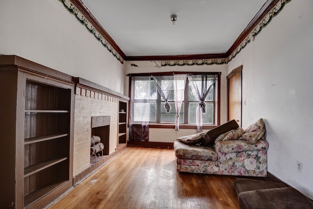 sitting room with ornamental molding, a fireplace, and hardwood / wood-style floors