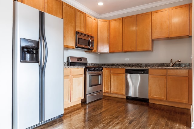 kitchen with stainless steel appliances, dark wood-type flooring, sink, dark stone counters, and ornamental molding