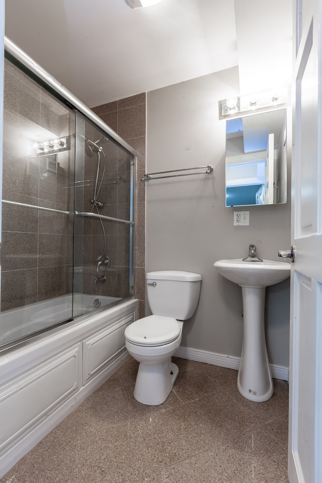 bathroom with shower / bath combination with glass door and toilet