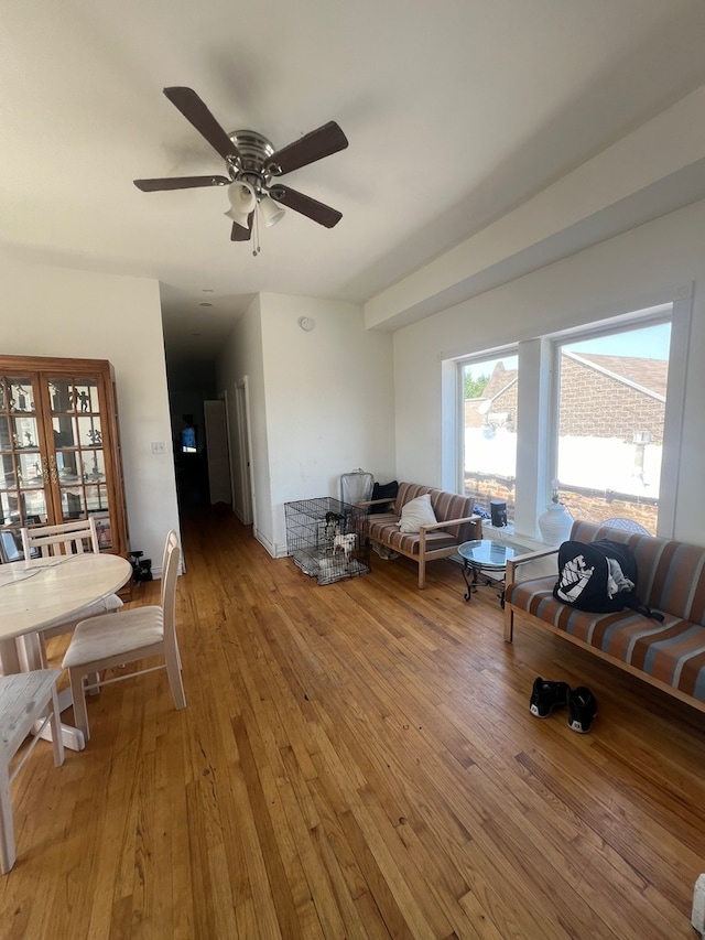 living room with ceiling fan and light hardwood / wood-style flooring