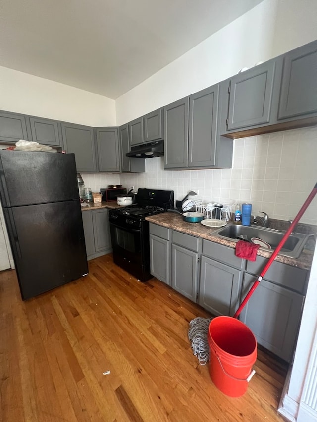 kitchen featuring gray cabinetry, light wood-type flooring, sink, and black appliances