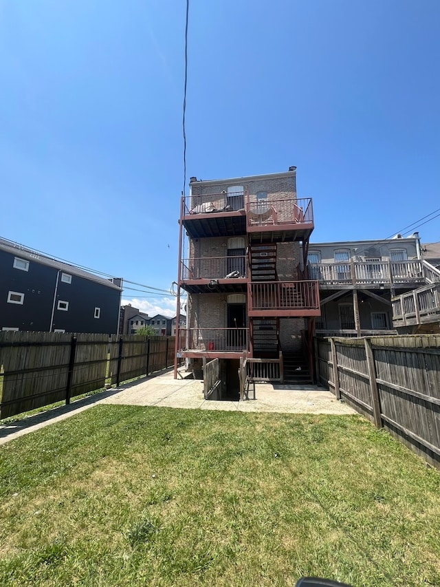 back of property featuring a yard, a deck, and a patio